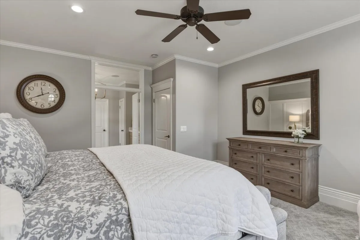 Neutral-toned bedroom featuring crown molding, recessed lighting, and a ceiling fan