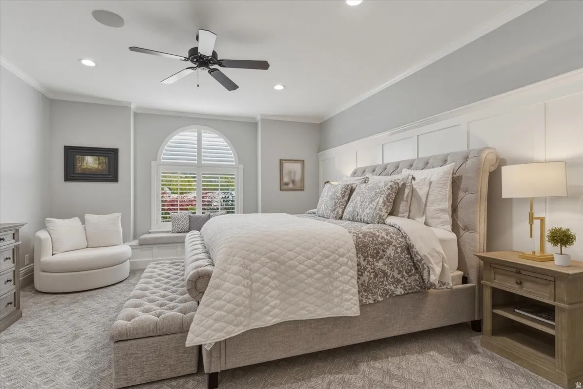 Bedroom featuring a large arched window with plantation shutters, recessed lighting, and crown molding