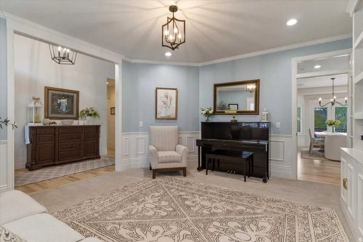 Open living area featuring light blue walls with wainscoting, recessed lighting, and a decorative ceiling fixture