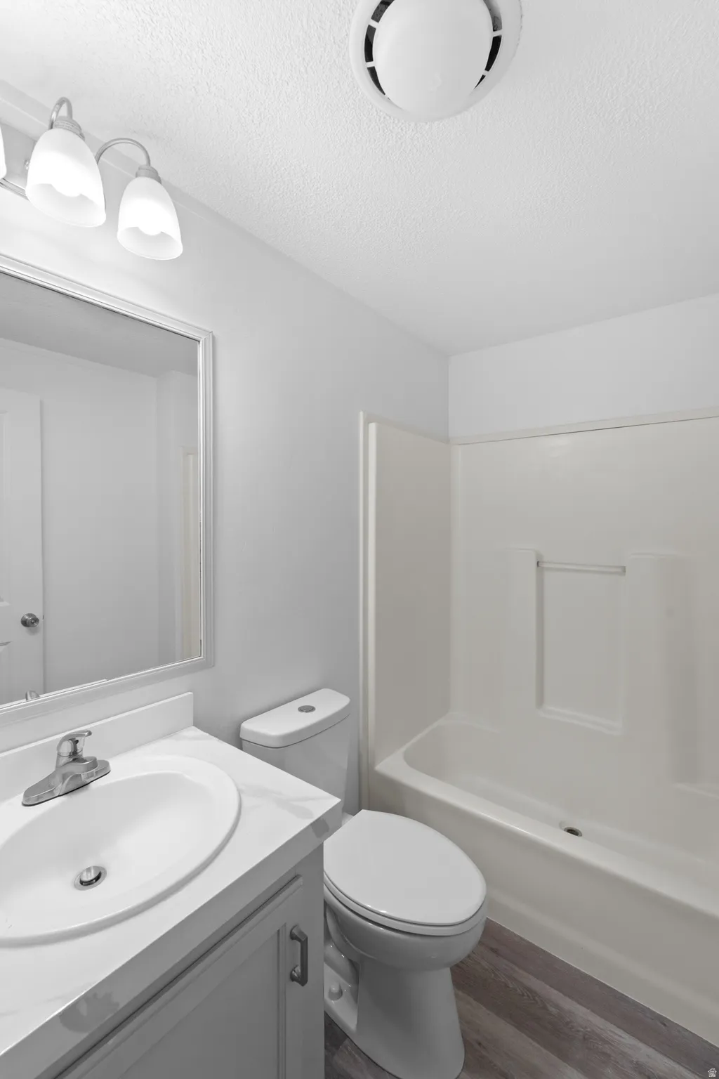 Bathroom featuring a white vanity with an undermount sink, a white countertop, and a vanity mirror