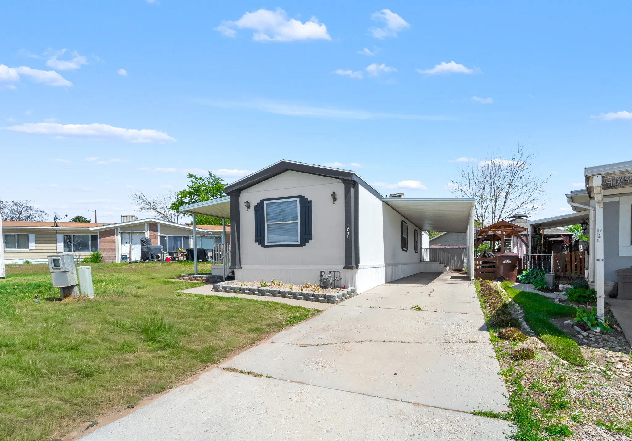 Single-story residence featuring a carport, concrete driveway, and a front facade with decorative shutters