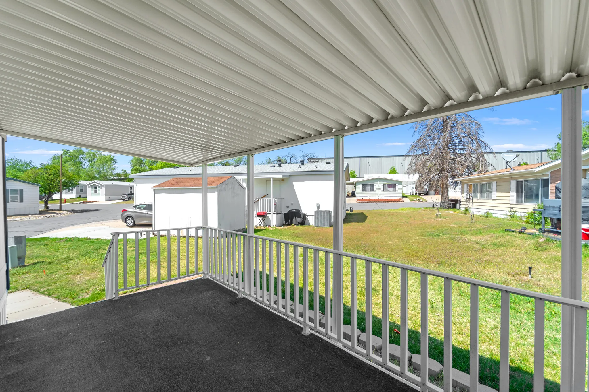 Covered porch featuring a ribbed metal roof and white railings