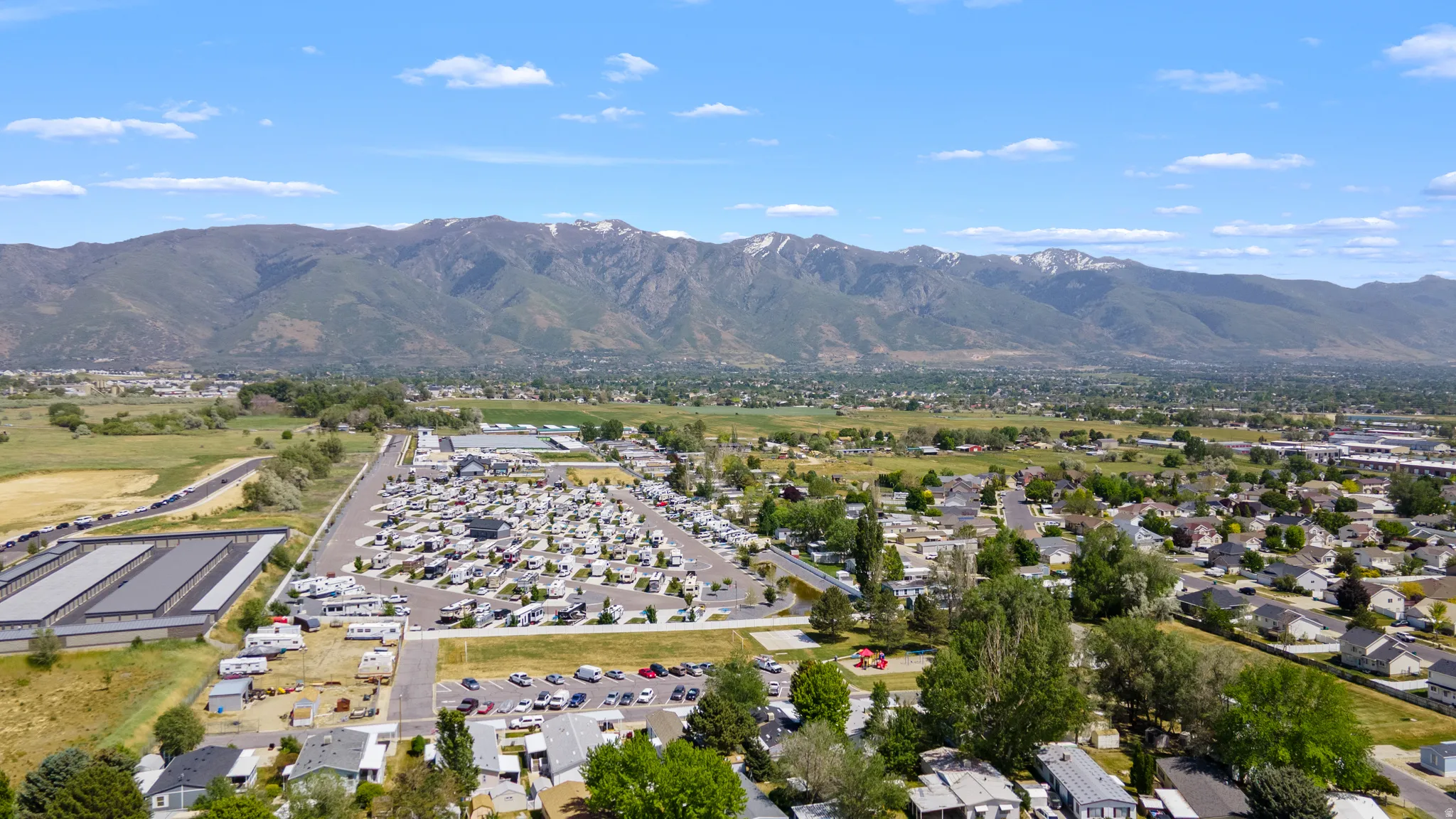 Expansive property showcasing a large recreational vehicle park, multiple storage buildings, and residential housing