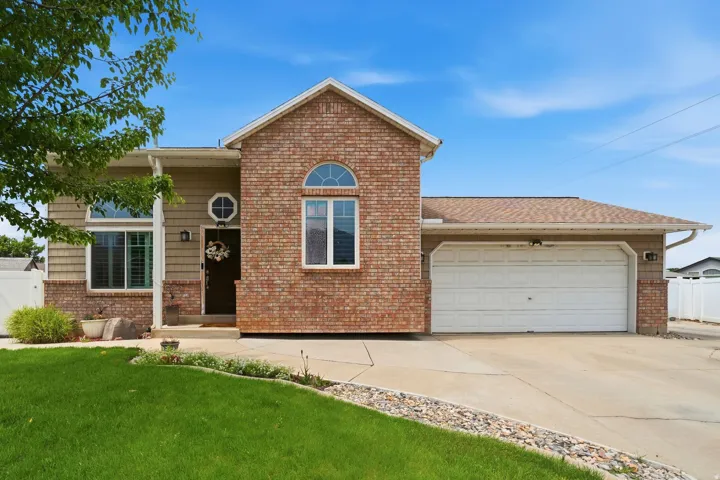 Brick and siding exterior featuring an attached two-car garage, arched window, and octagonal window