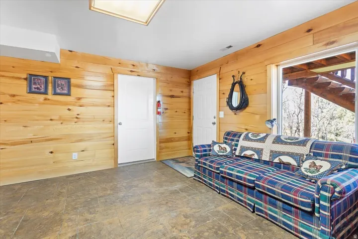 Wood-finish wall paneling throughout the space, featuring tile flooring and a ceiling light fixture