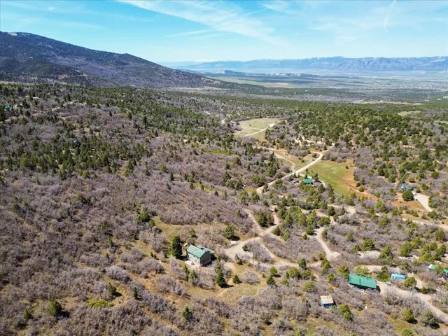 Expansive property featuring varied terrain, a distant mountain range, and multiple scattered structures
