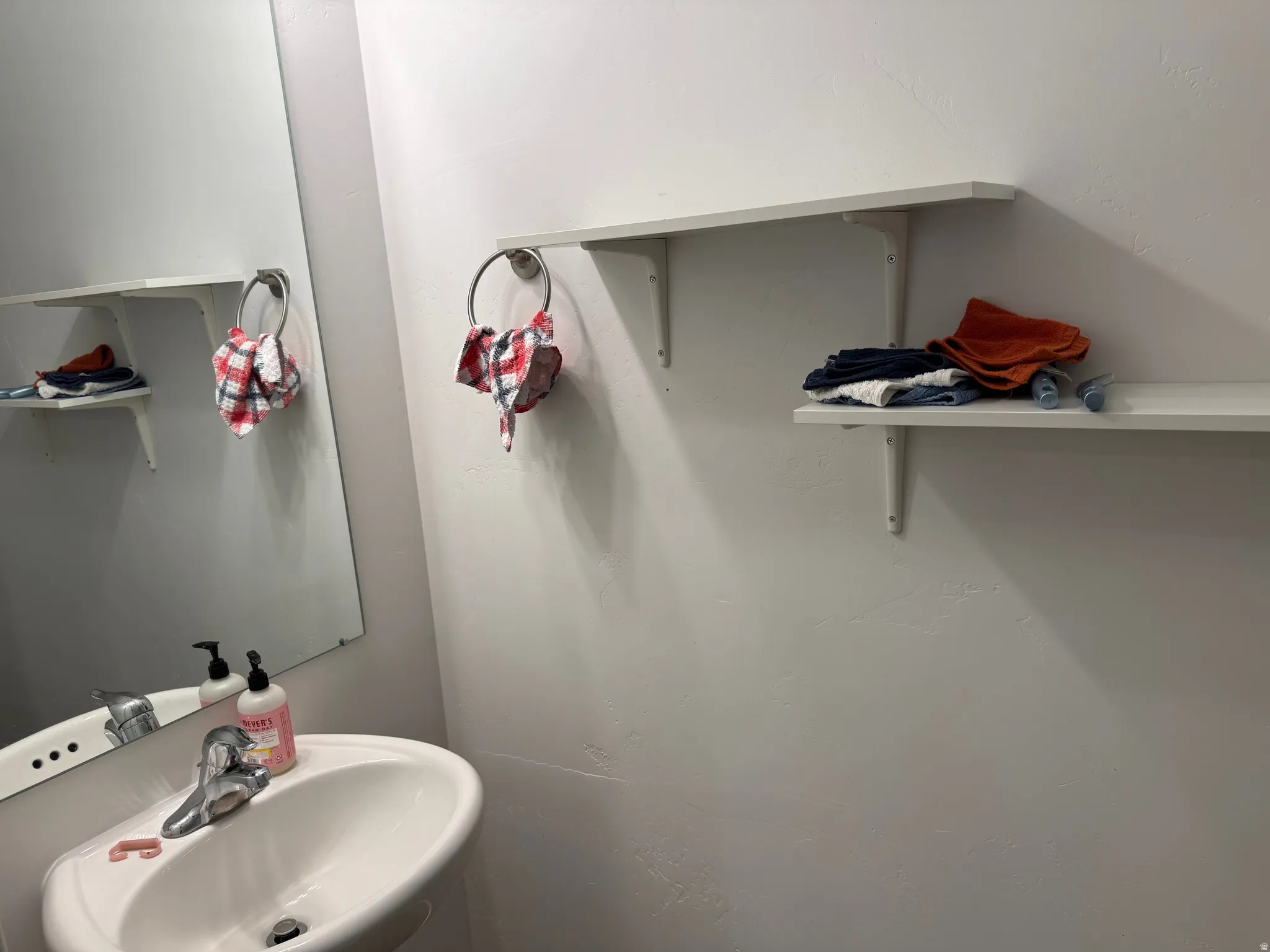 Pedestal sink with chrome faucet and mirror