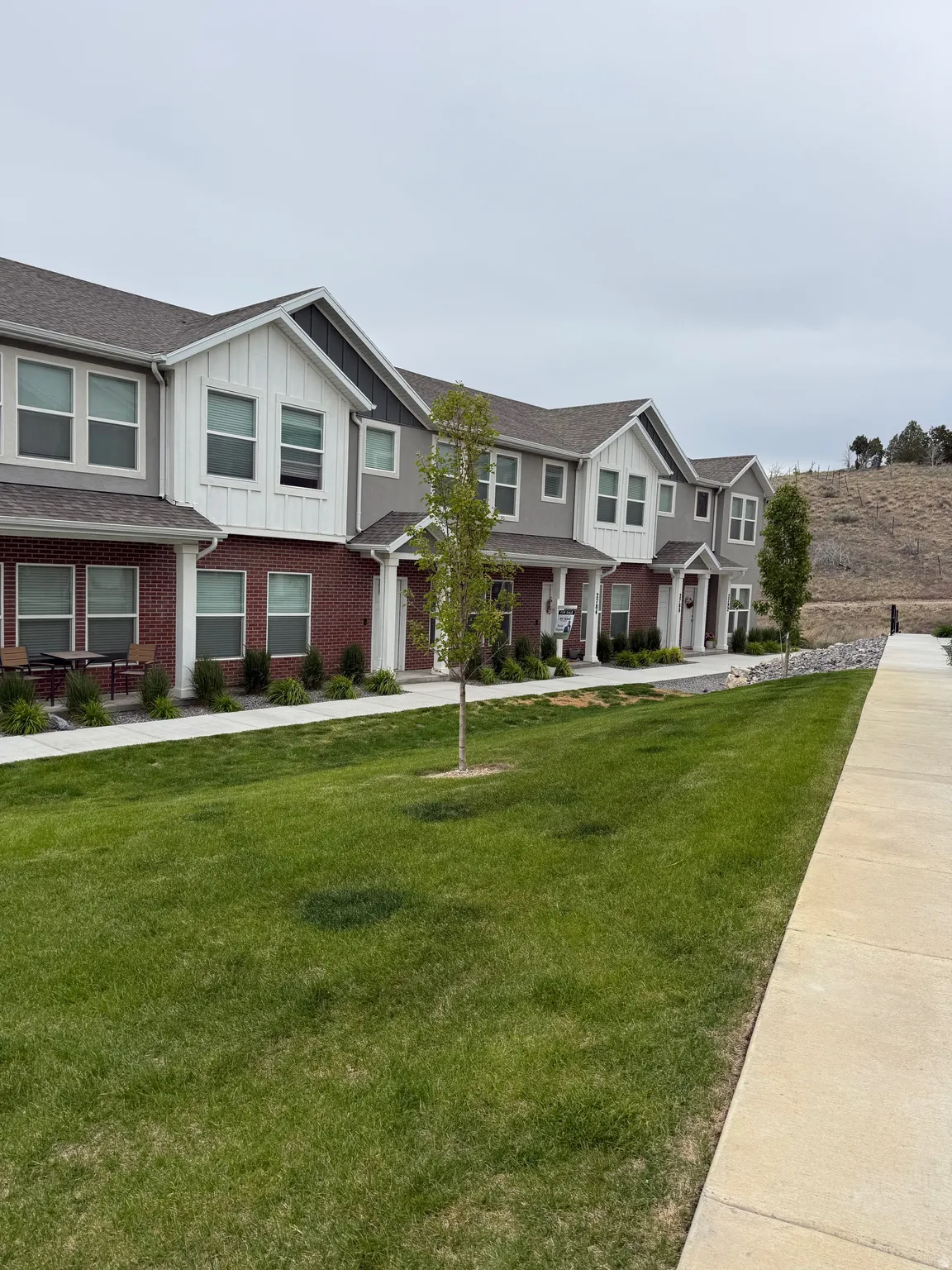 Modern townhome exteriors featuring red brick and gray siding accents