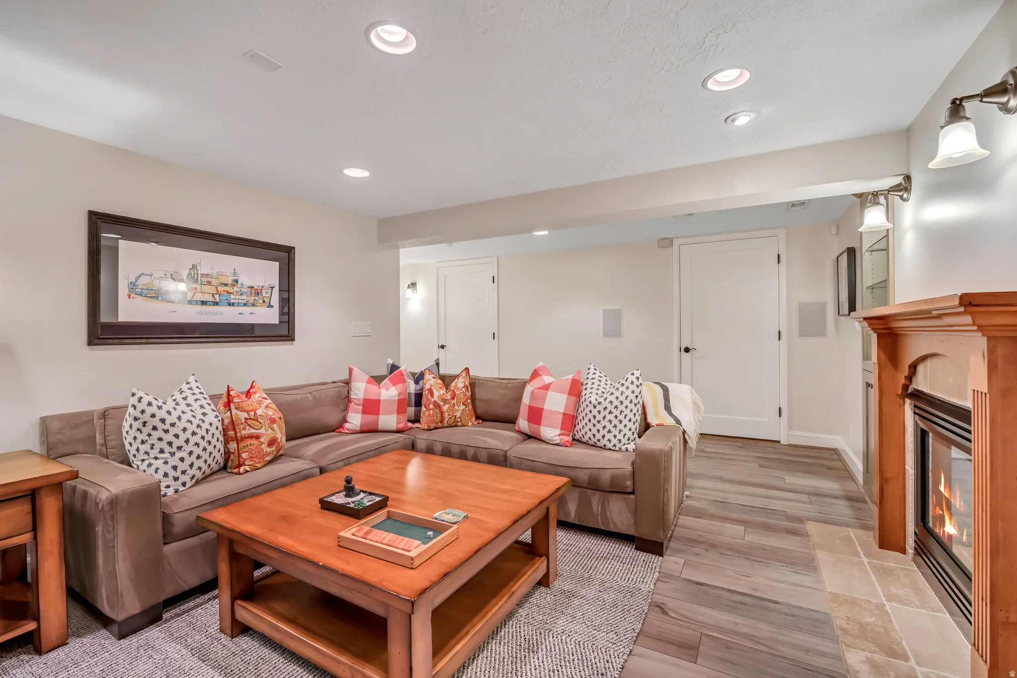 Living area featuring a gas fireplace with a wood-finished mantel, recessed lighting, and wood-finish flooring