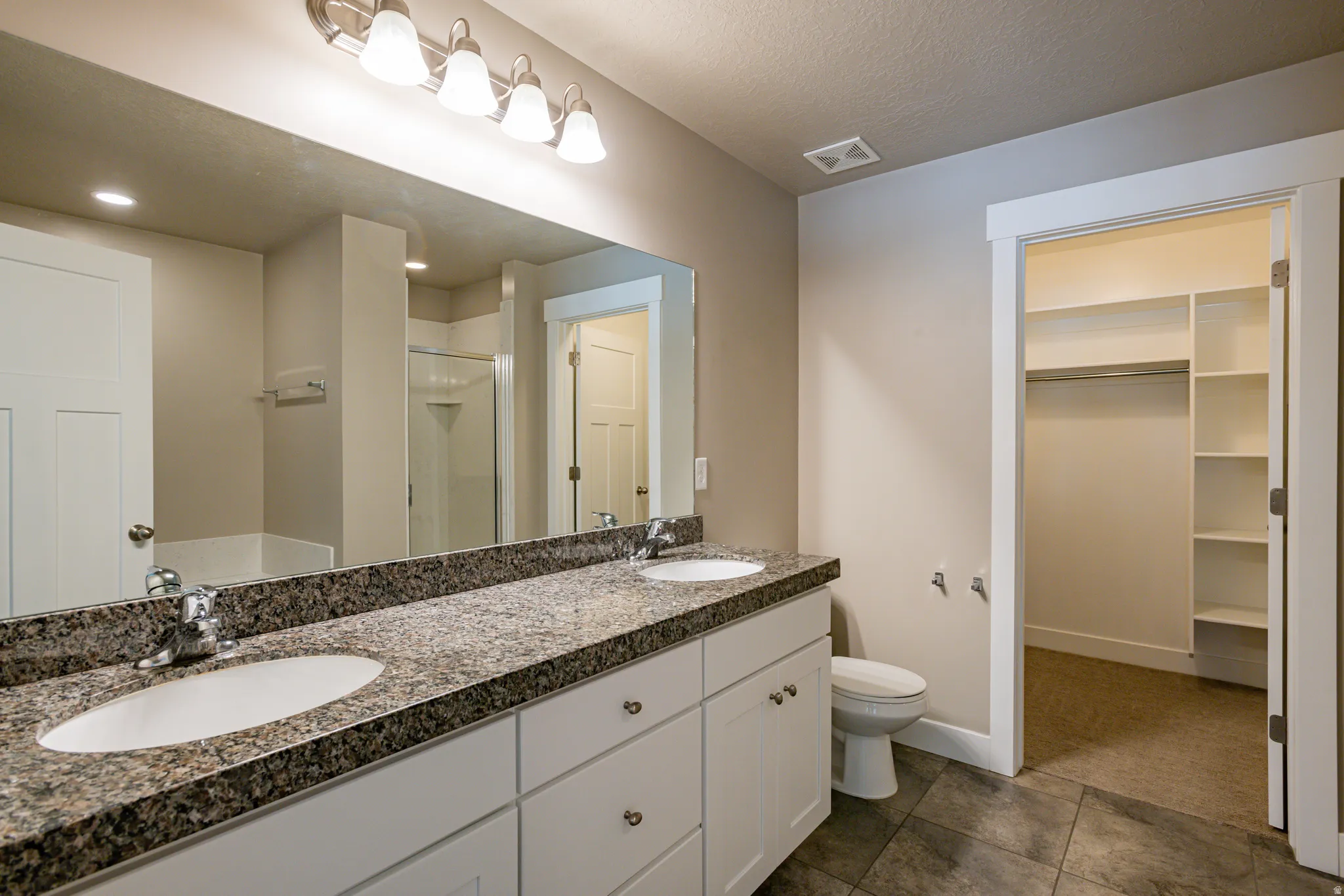 Spa-like primary bath with dual sinks, soaking tub, and separate shower.