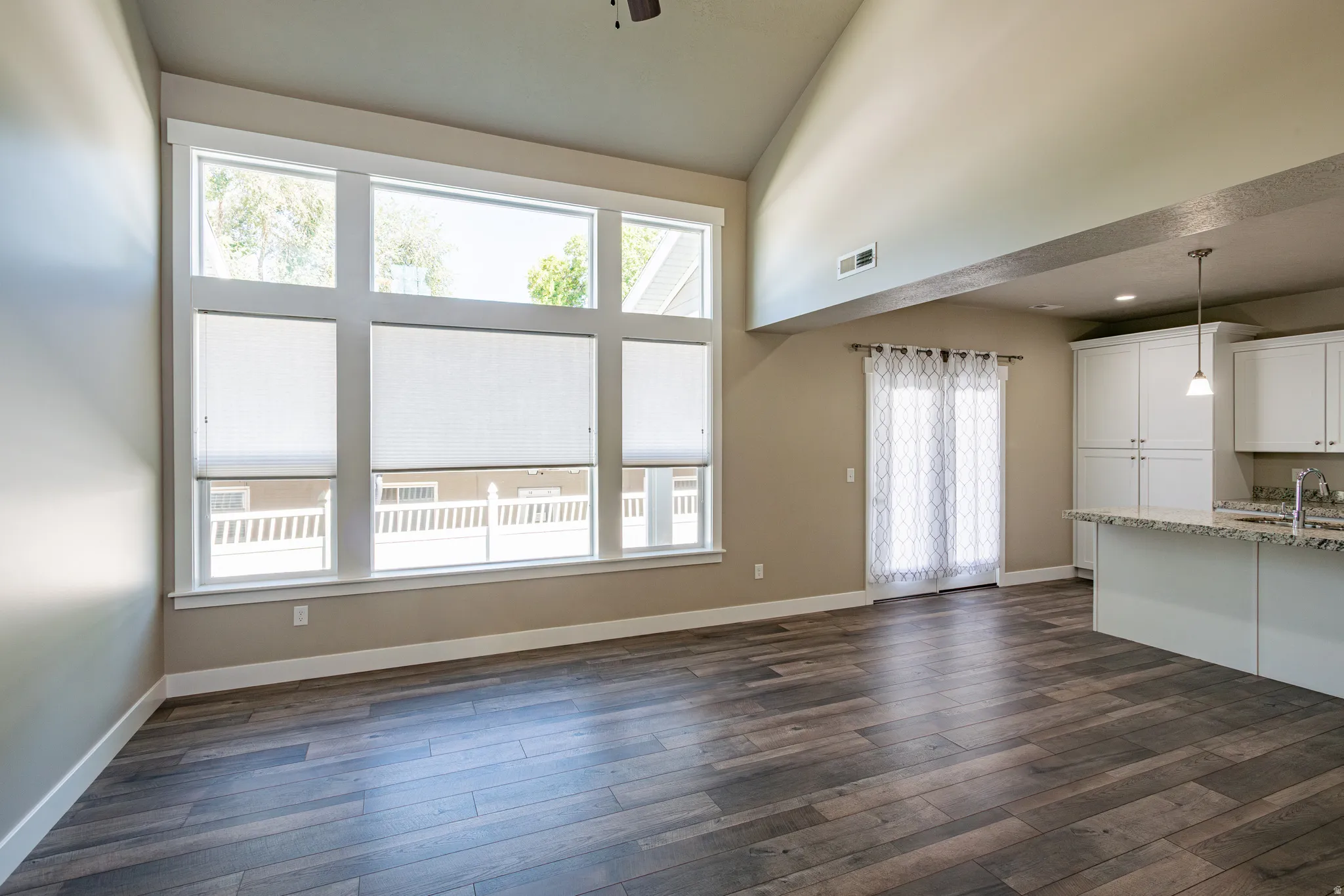 Great room featuring vaulted ceilings and a stunning wall of windows.
