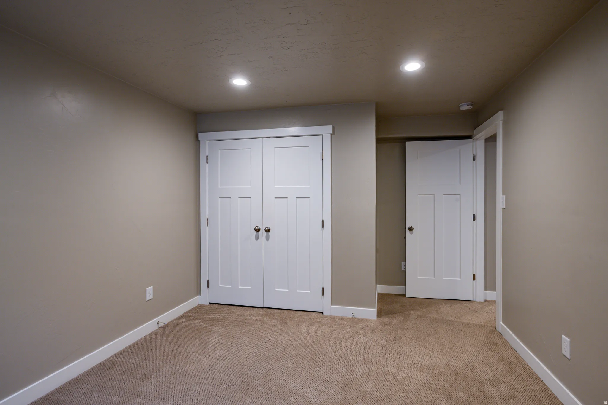Neutral-toned walls complement the carpeted flooring