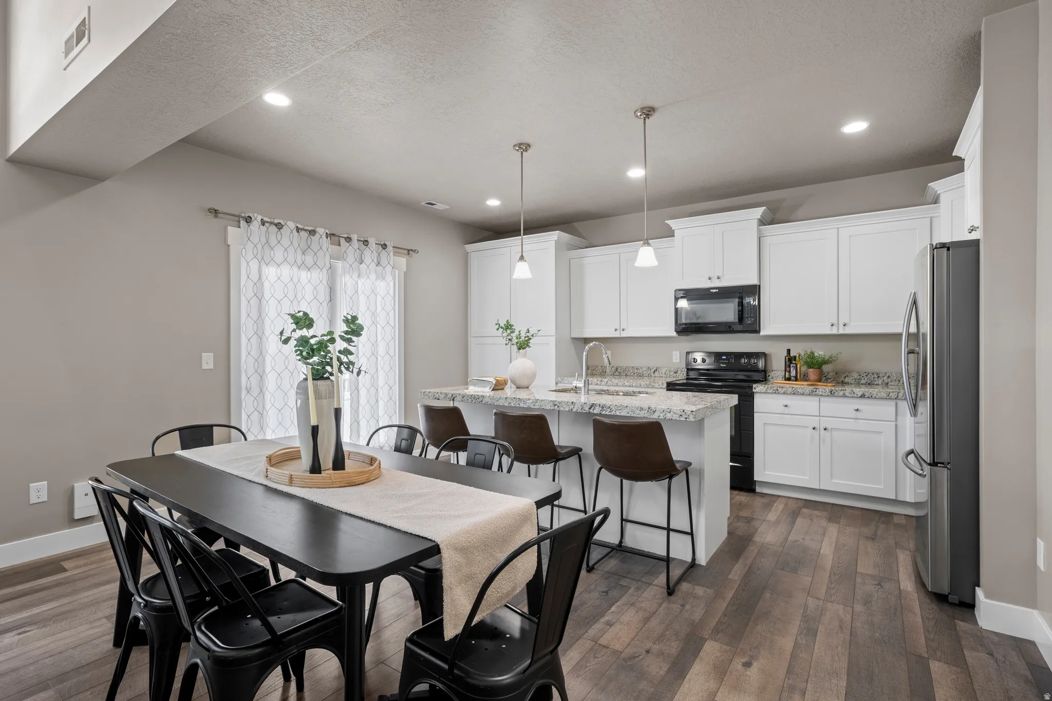 Open-concept kitchen and dining area featuring wood-finish flooring