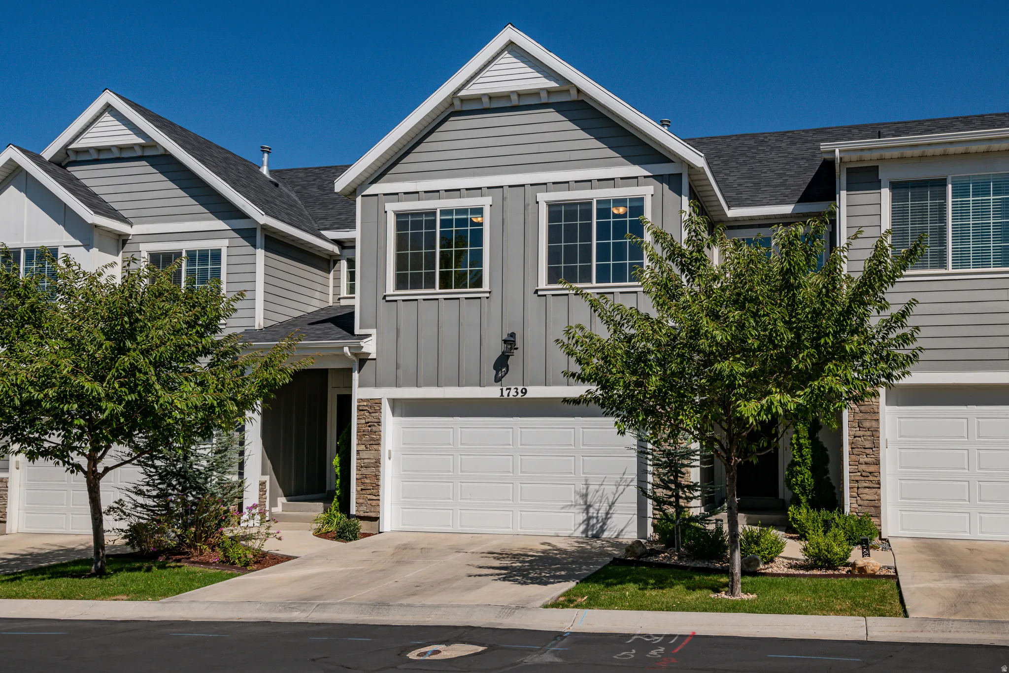 Charming multi-story exterior featuring a prominent gabled roofline, stone accents, and a 2-car garage.