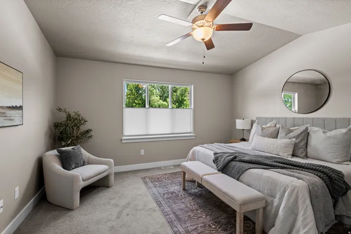 Vaulted ceiling featuring a ceiling fan with integrated lighting, window with privacy blinds, plush carpet flooring, and neutral wall tones