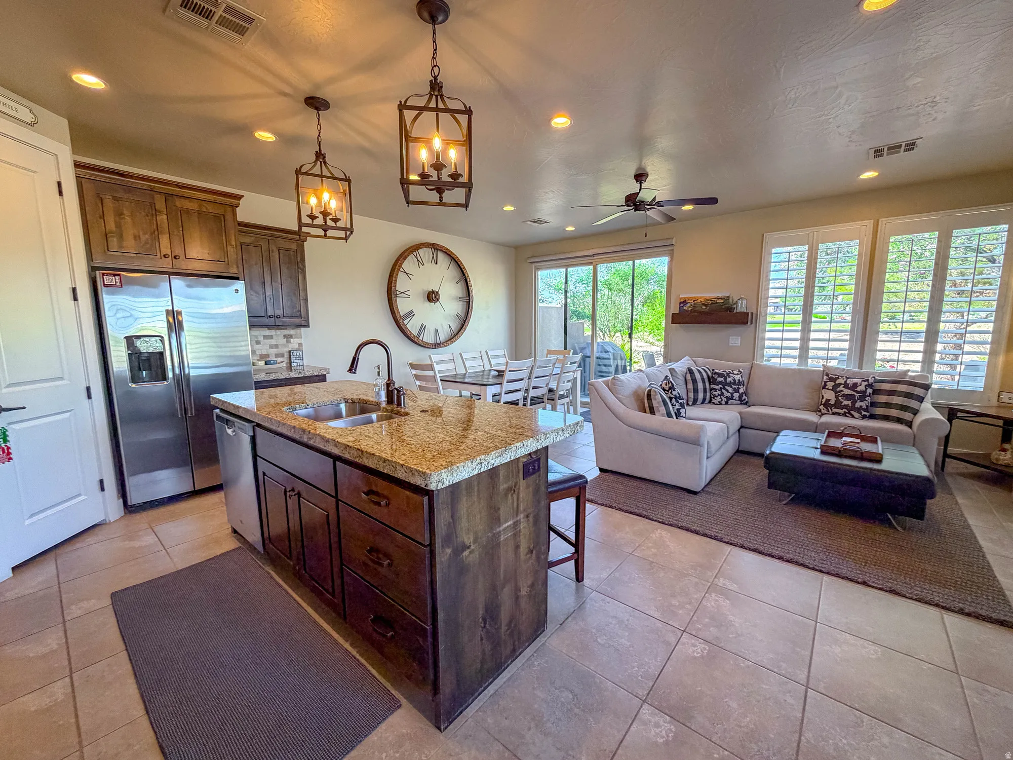 Open-concept living space with a kitchen island, recessed lighting, and patio access
