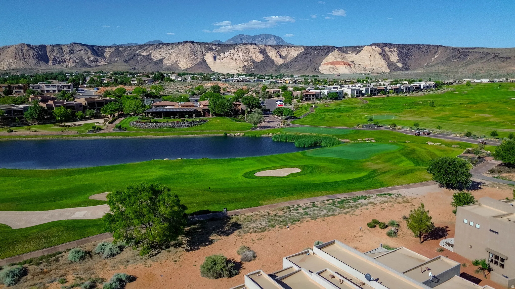 Expansive property featuring a golf course, a large body of water, and surrounding residential structures