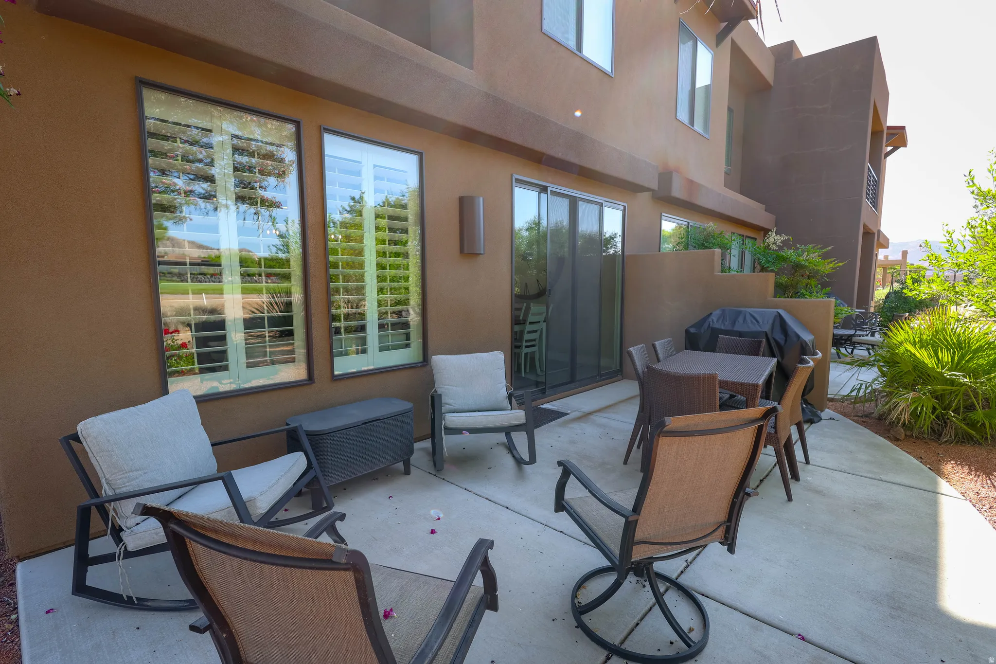Expansive concrete patio bordered by mature landscaping
