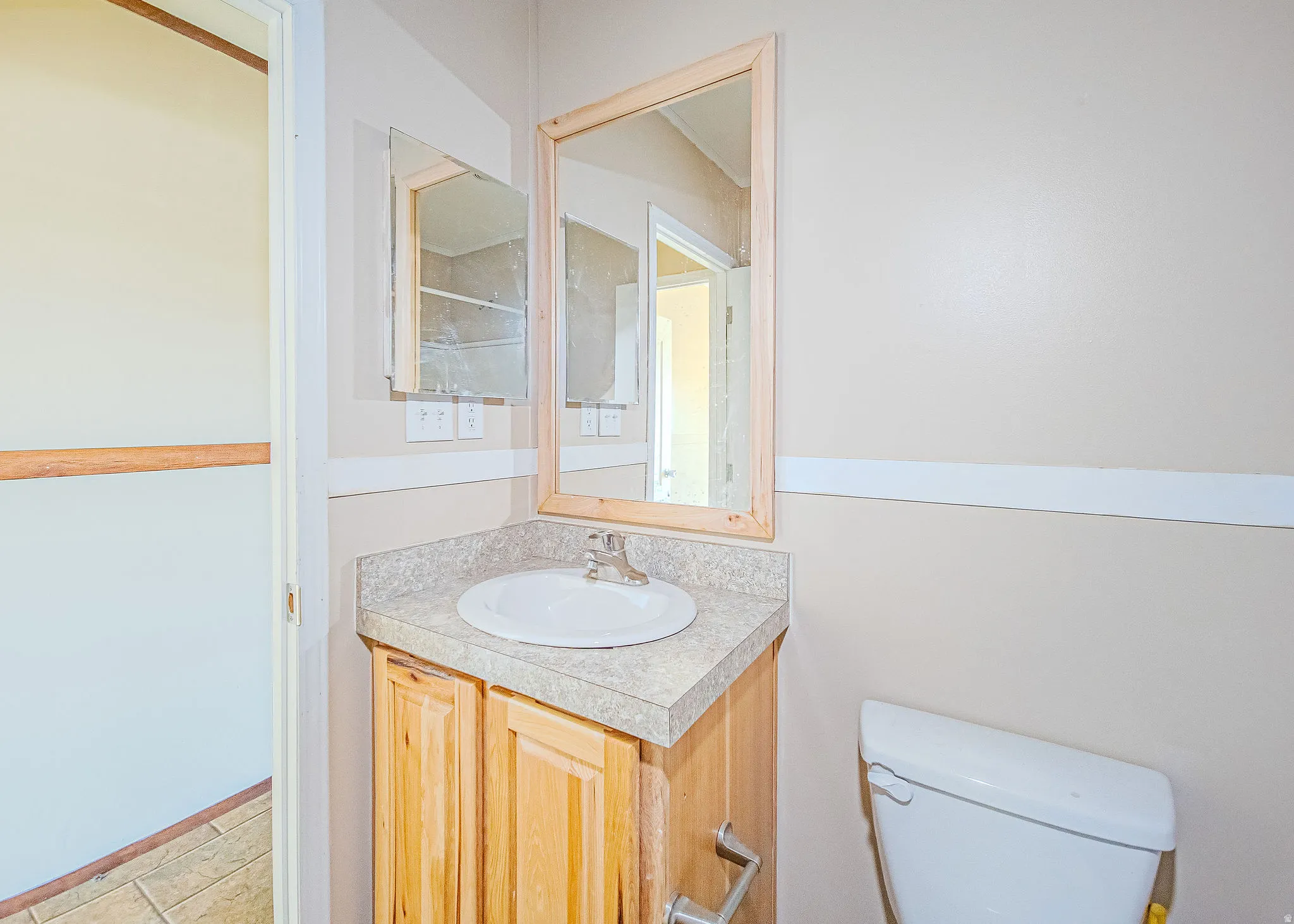 Bathroom vanity with a round sink, a single-handle faucet, and a light wood-finish cabinet