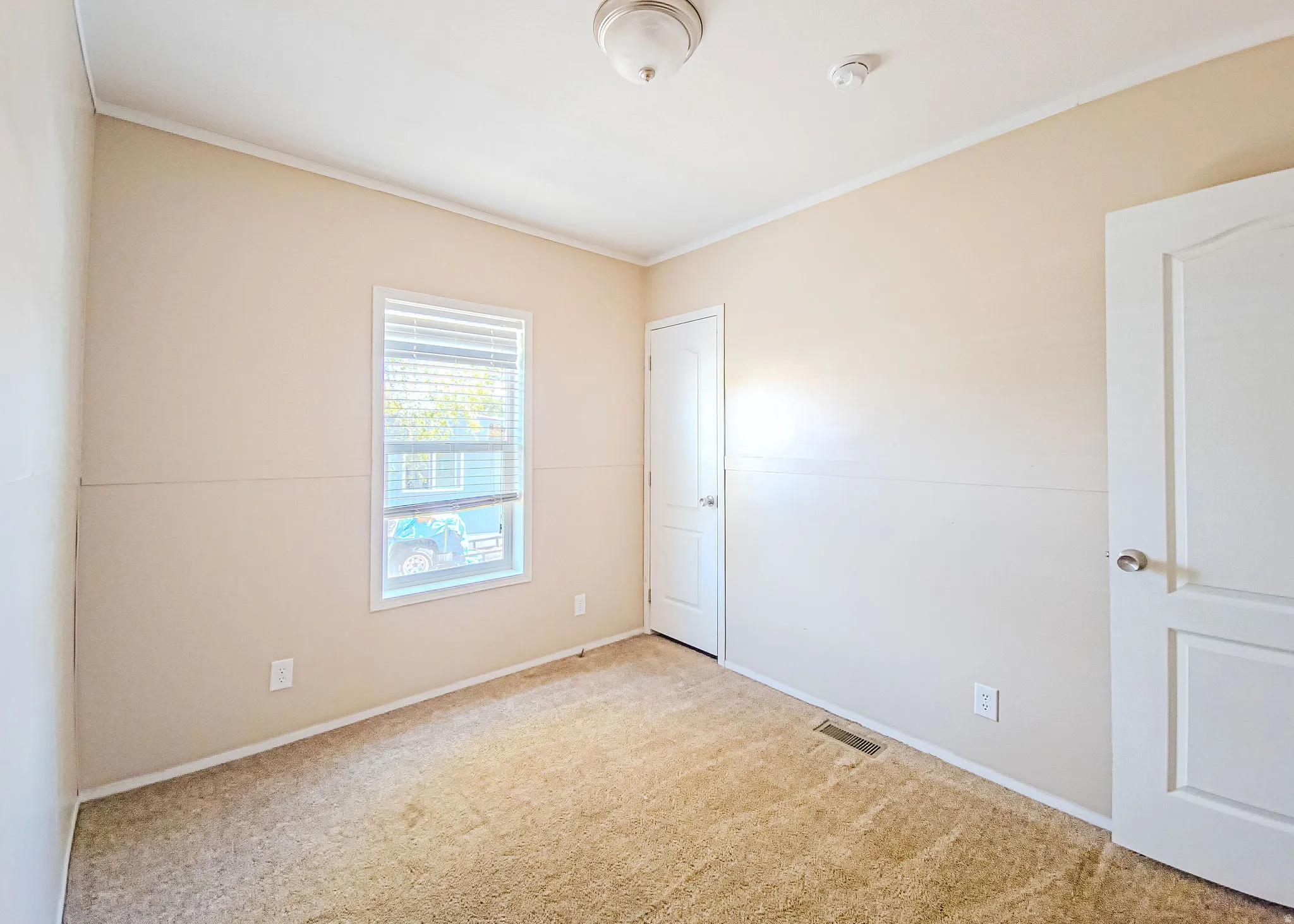 Neutral tone walls with white trim, a double-paned window, and a flush mount ceiling light