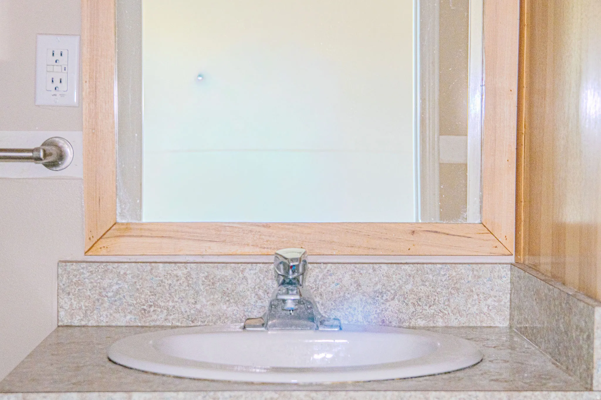 Recessed sink with a single-handle faucet, set into a speckled countertop