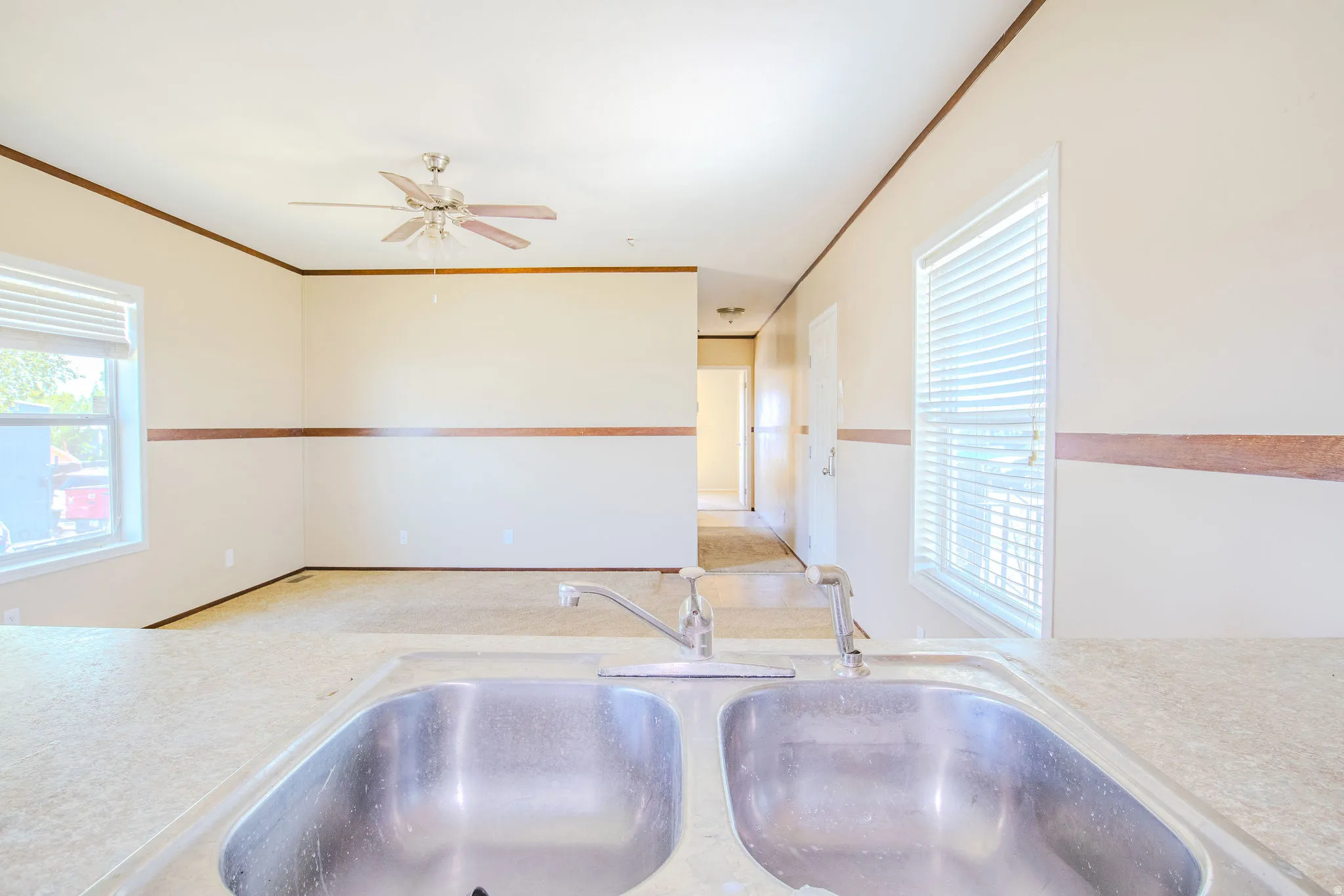 Double basin stainless steel sink with a deck-mounted faucet set into a speckled countertop