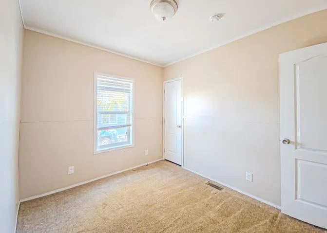 Neutral tone walls with white trim, a double-paned window, and a flush mount ceiling light