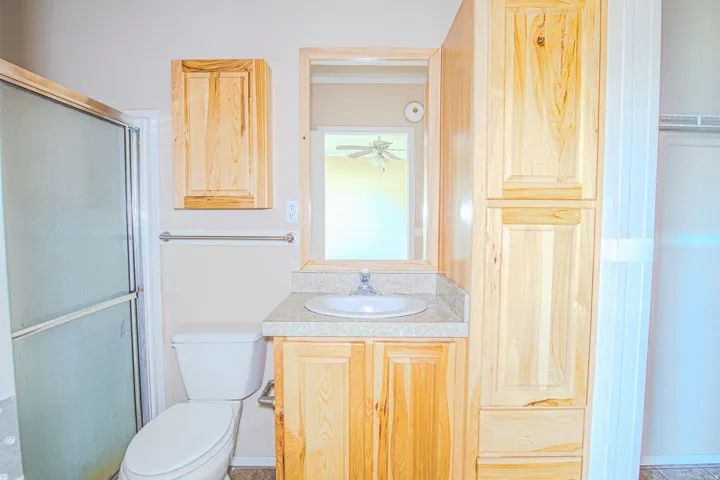 Bathroom vanity with a white basin sink, polished chrome faucet, and a light-toned countertop