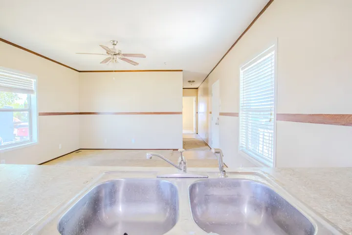 Double basin stainless steel sink with a deck-mounted faucet set into a speckled countertop