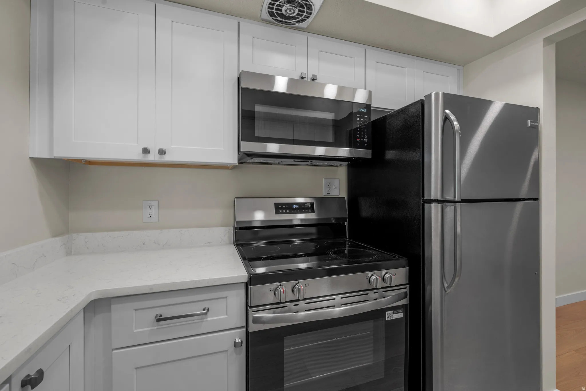Kitchen featuring white upper cabinetry, white lower cabinetry, and a light quartz countertop