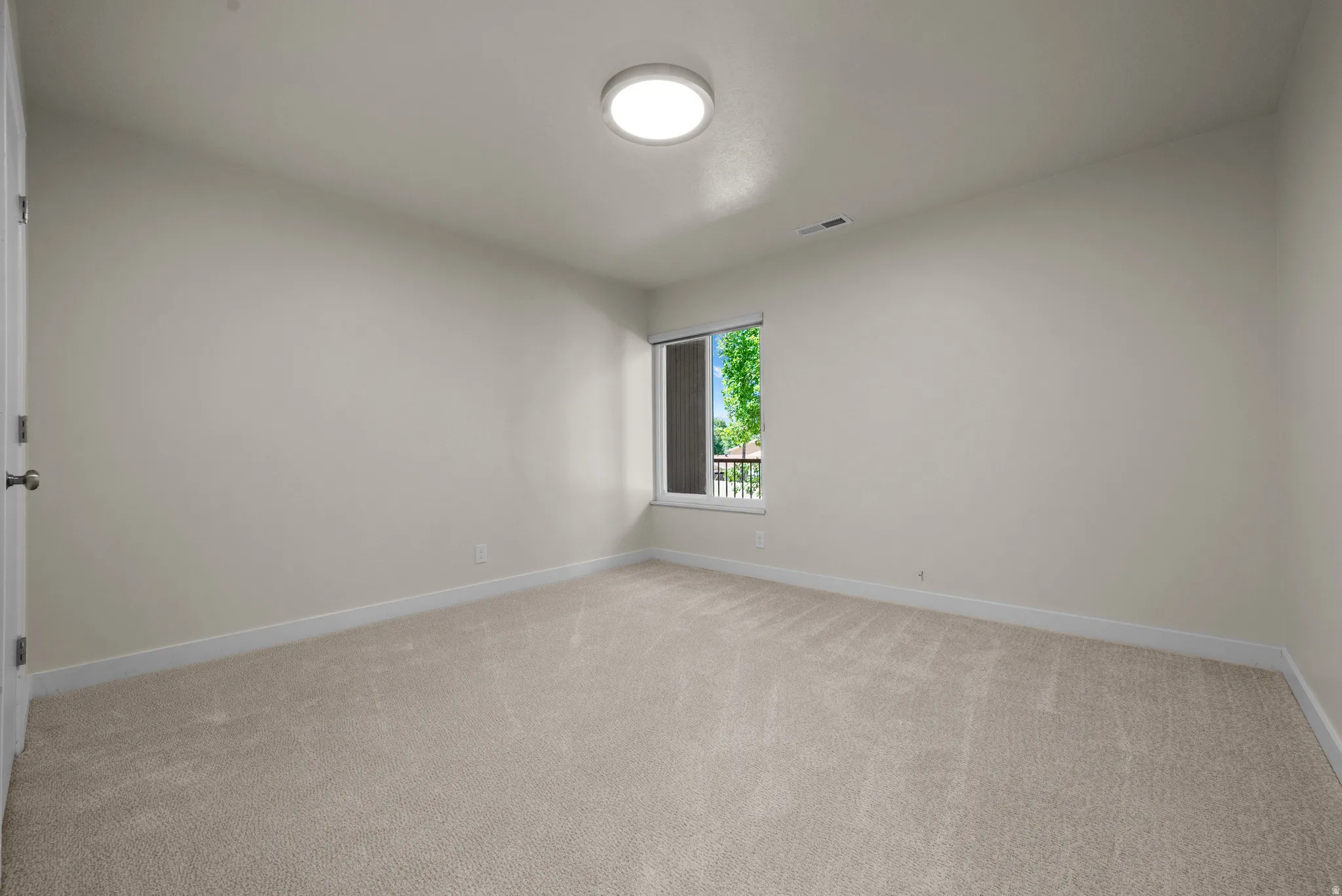 Neutral-toned walls and plush carpet flooring throughout this room