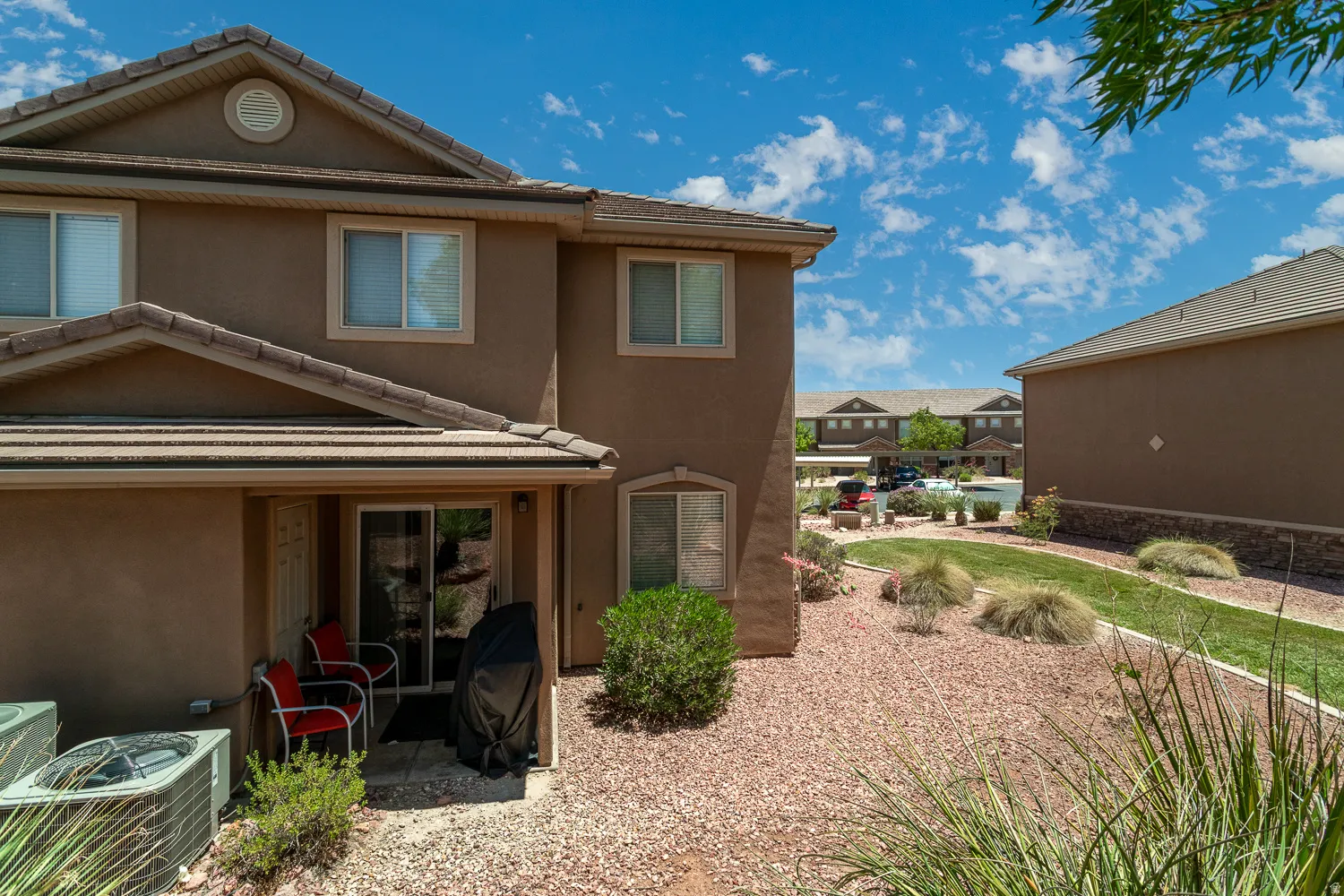 Stucco exterior residence featuring a covered patio with a sliding glass door