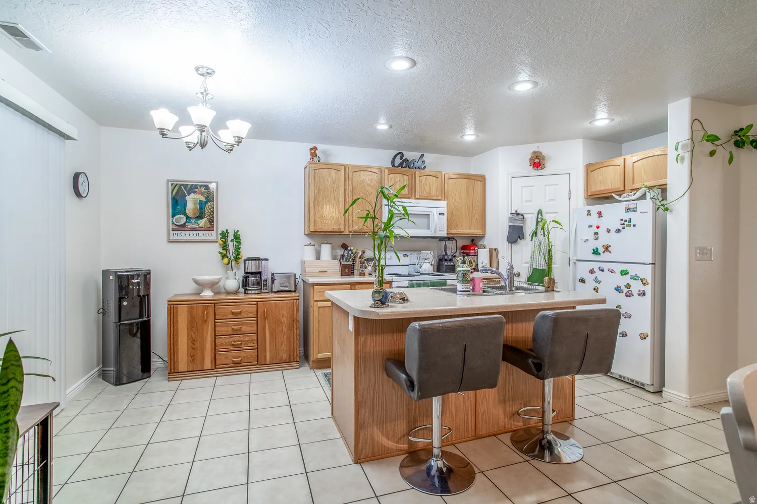 Kitchen featuring light wood-finish cabinetry and a complementary island with seating space