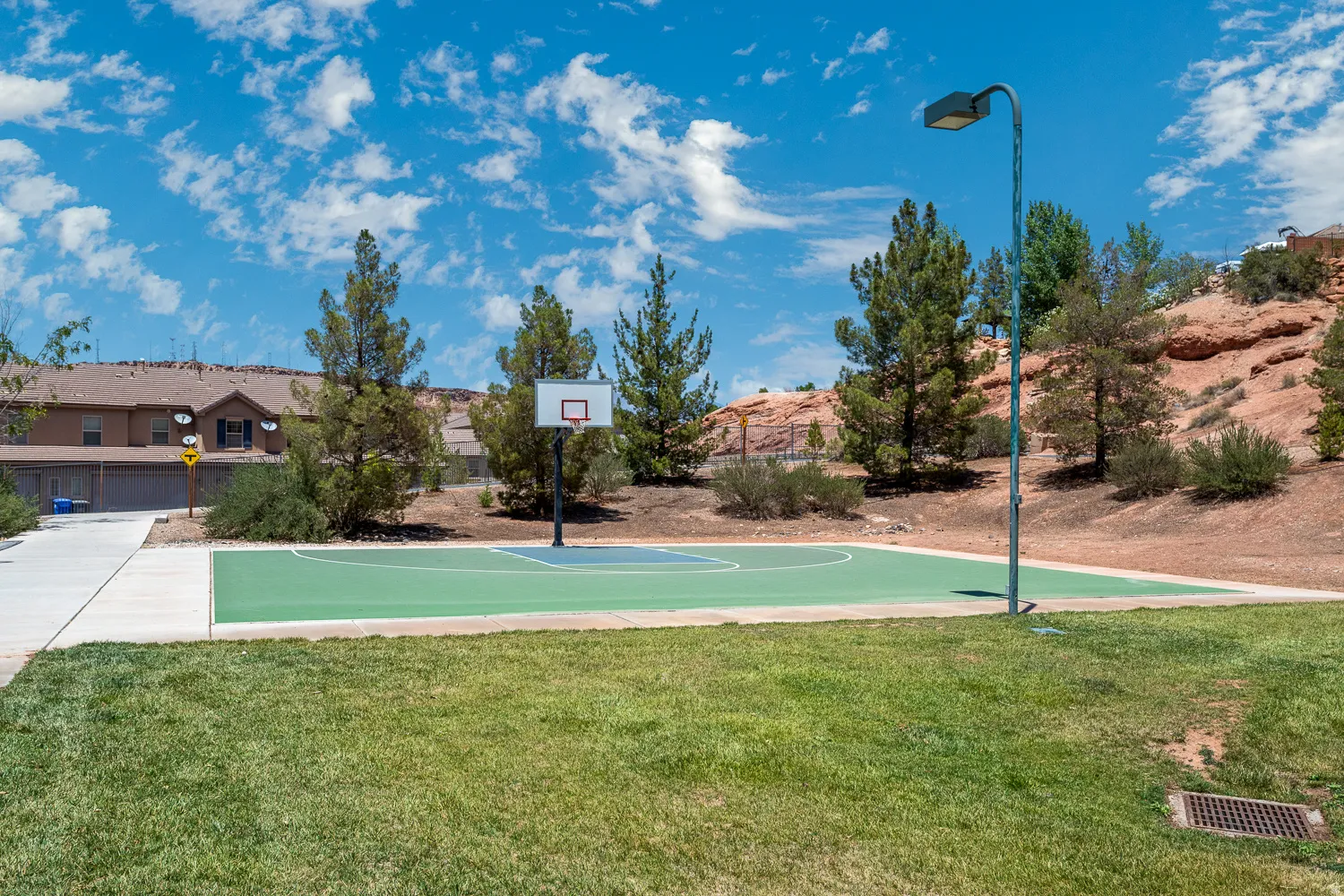 Outdoor recreation court with a basketball hoop and light fixture