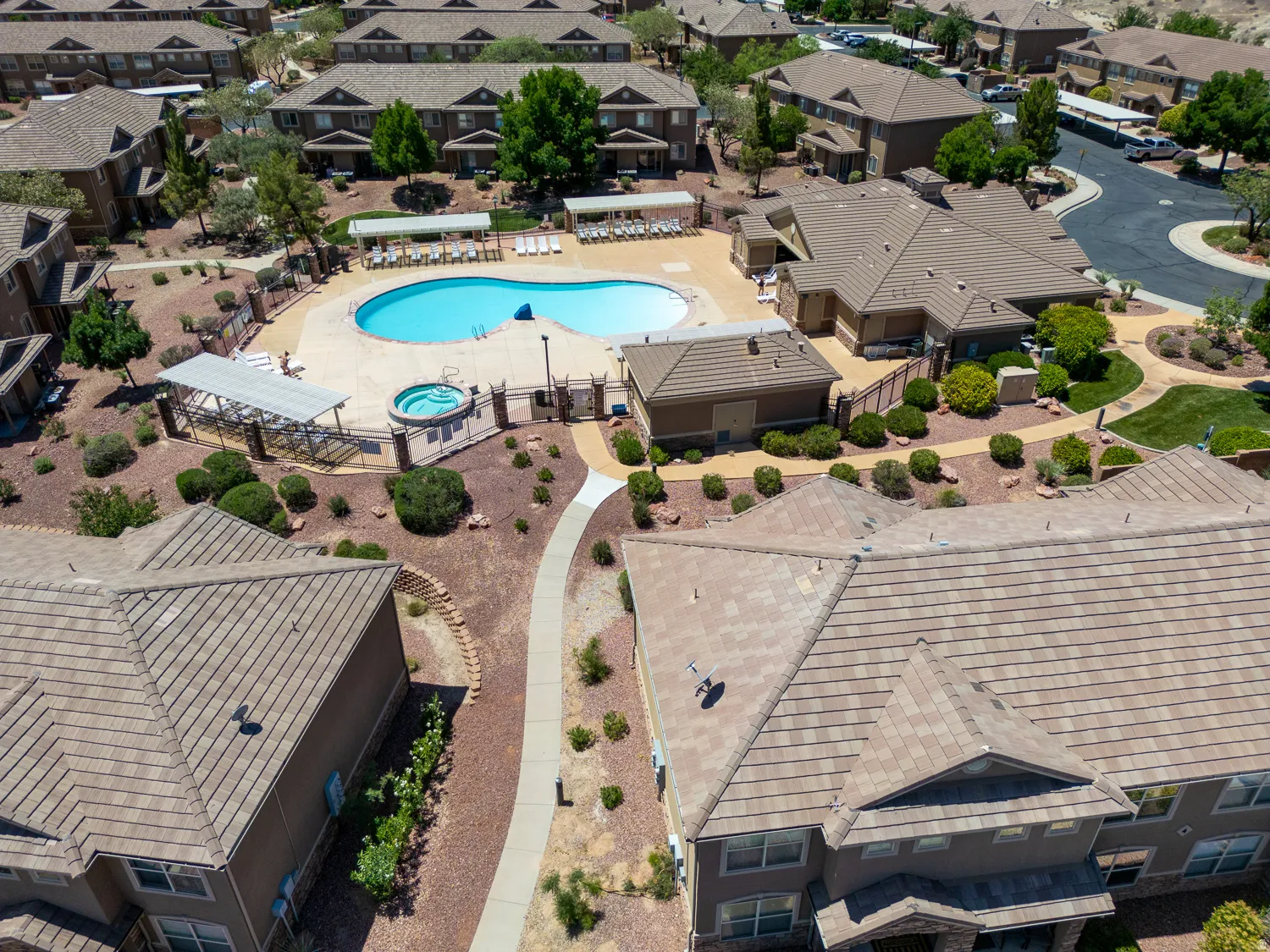 Outdoor swimming pool featuring a hot tub, surrounding paved deck, and adjacent lounge seating