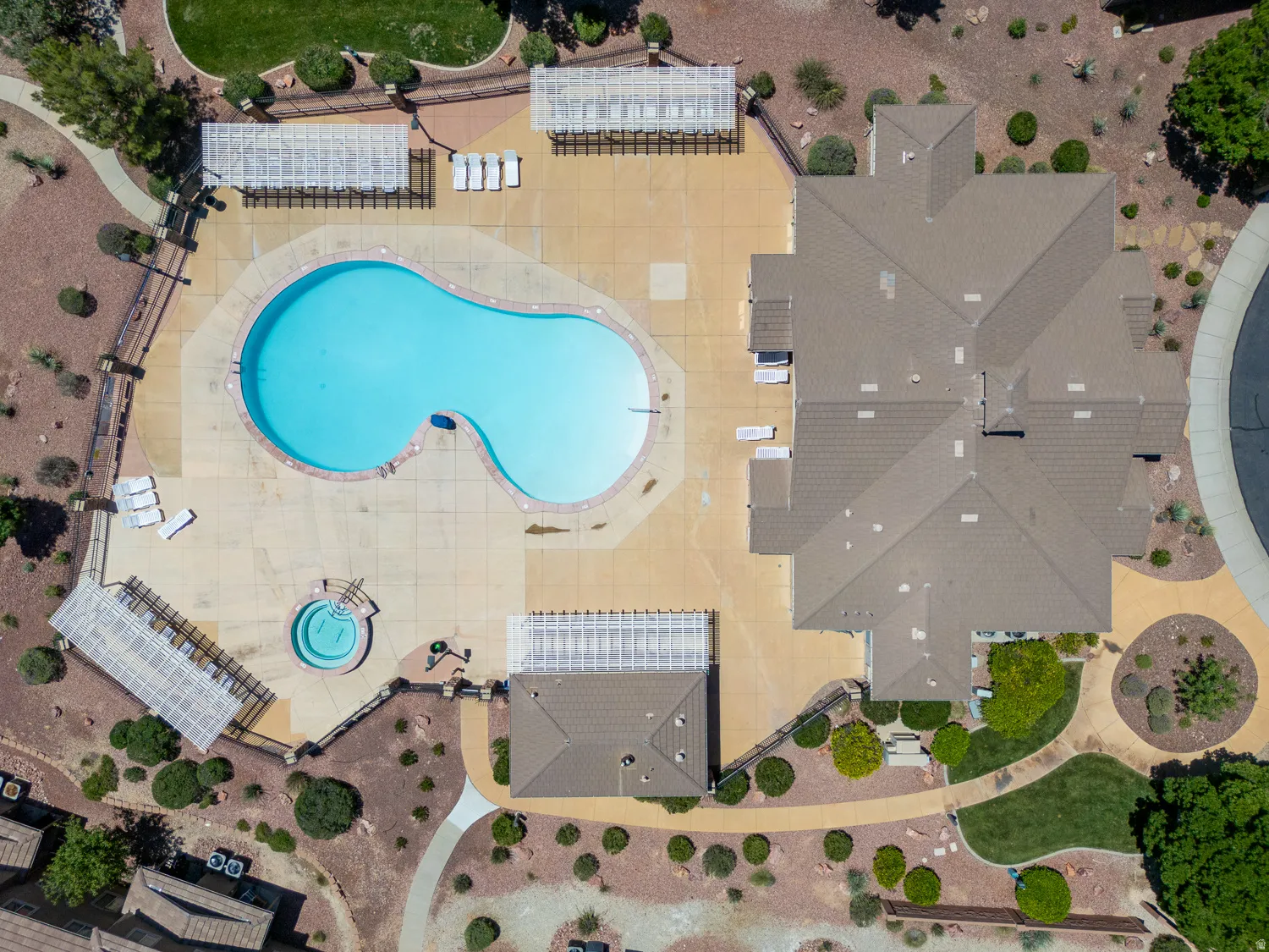Figural swimming pool with an integrated spa, surrounded by expansive concrete decking