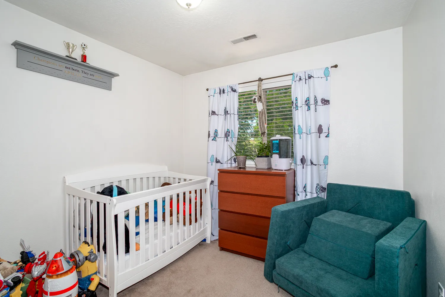 White interior walls featuring a window with horizontal blinds and decorative curtains