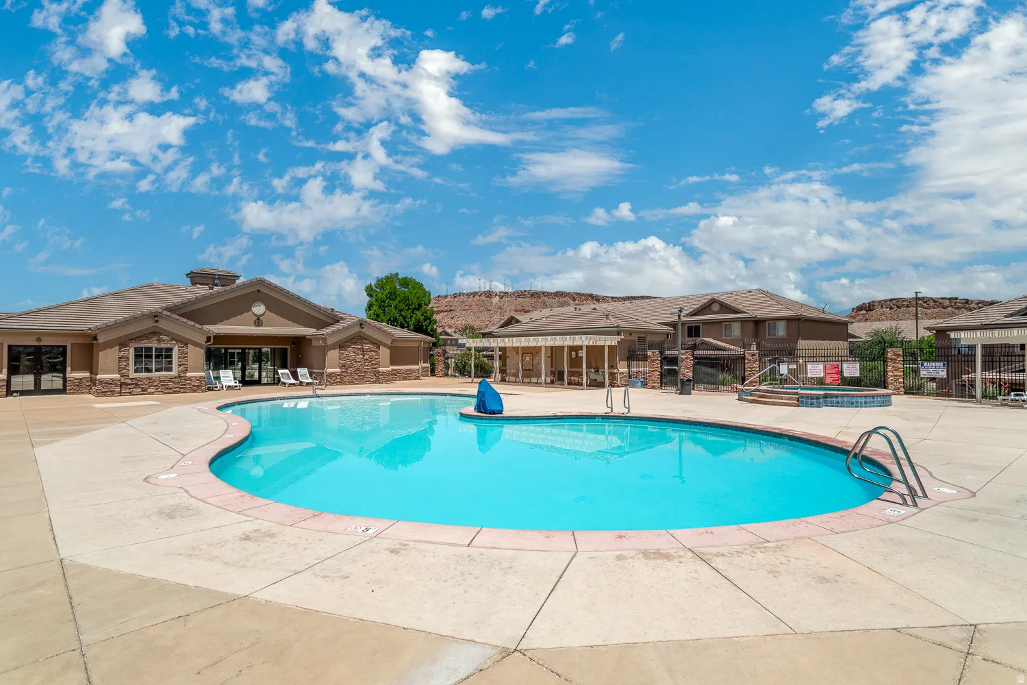 Large resort-style swimming pool featuring a curved design and integrated spa