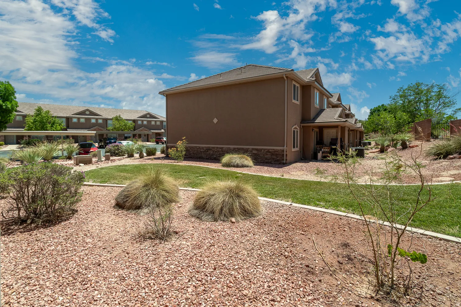 Exterior building featuring stucco siding, stone veneer accents, and multiple windows