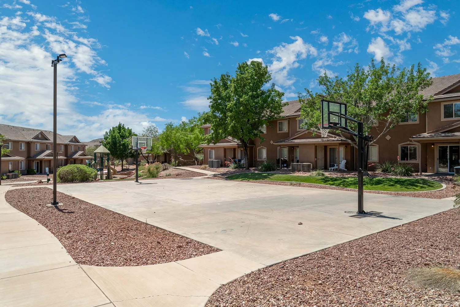 Concrete sports court featuring two basketball hoops
