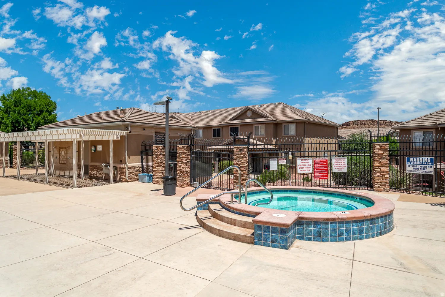Outdoor spa with blue tile surround and stone steps