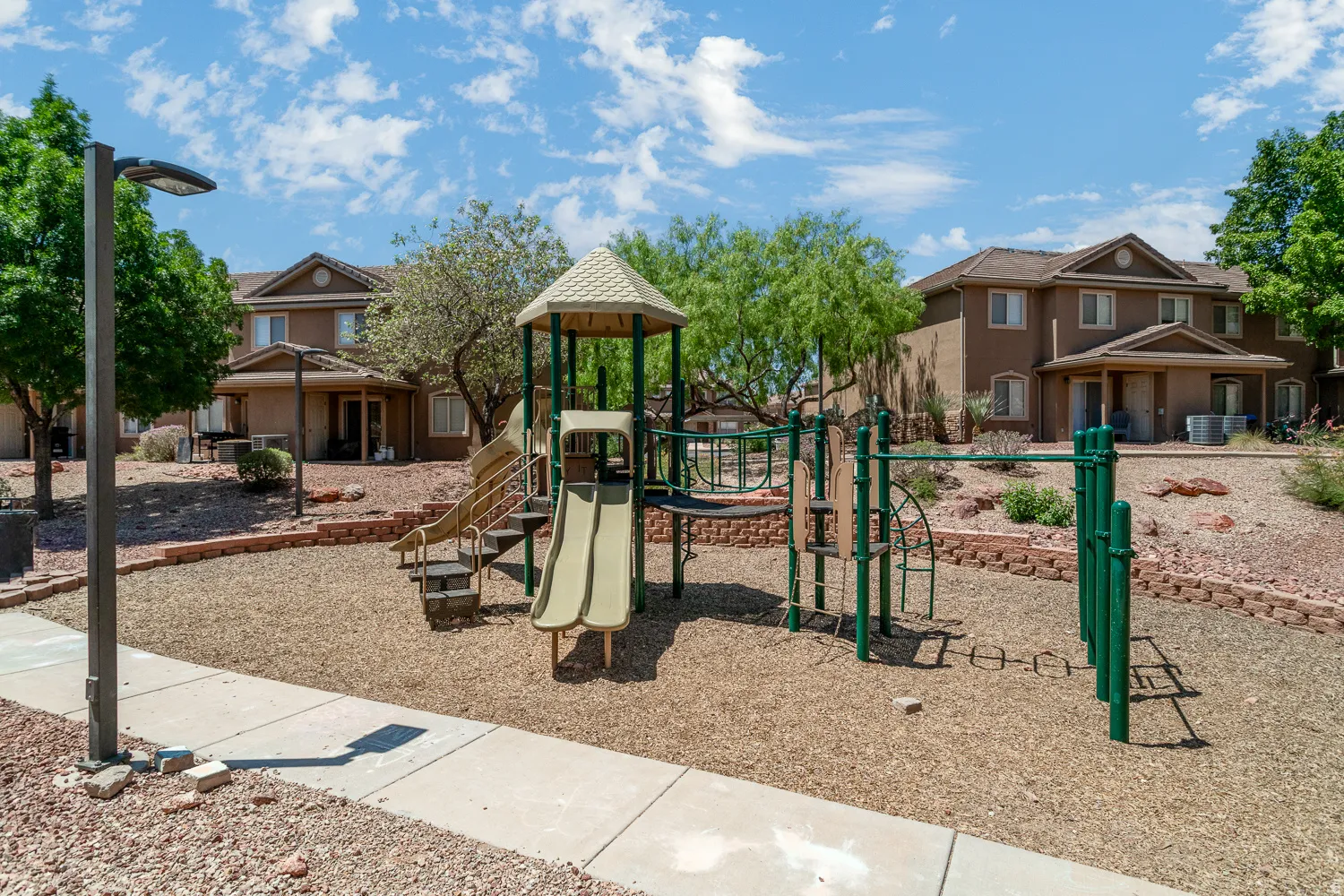 On-site playground featuring a slide, climbing structures, and ground covering