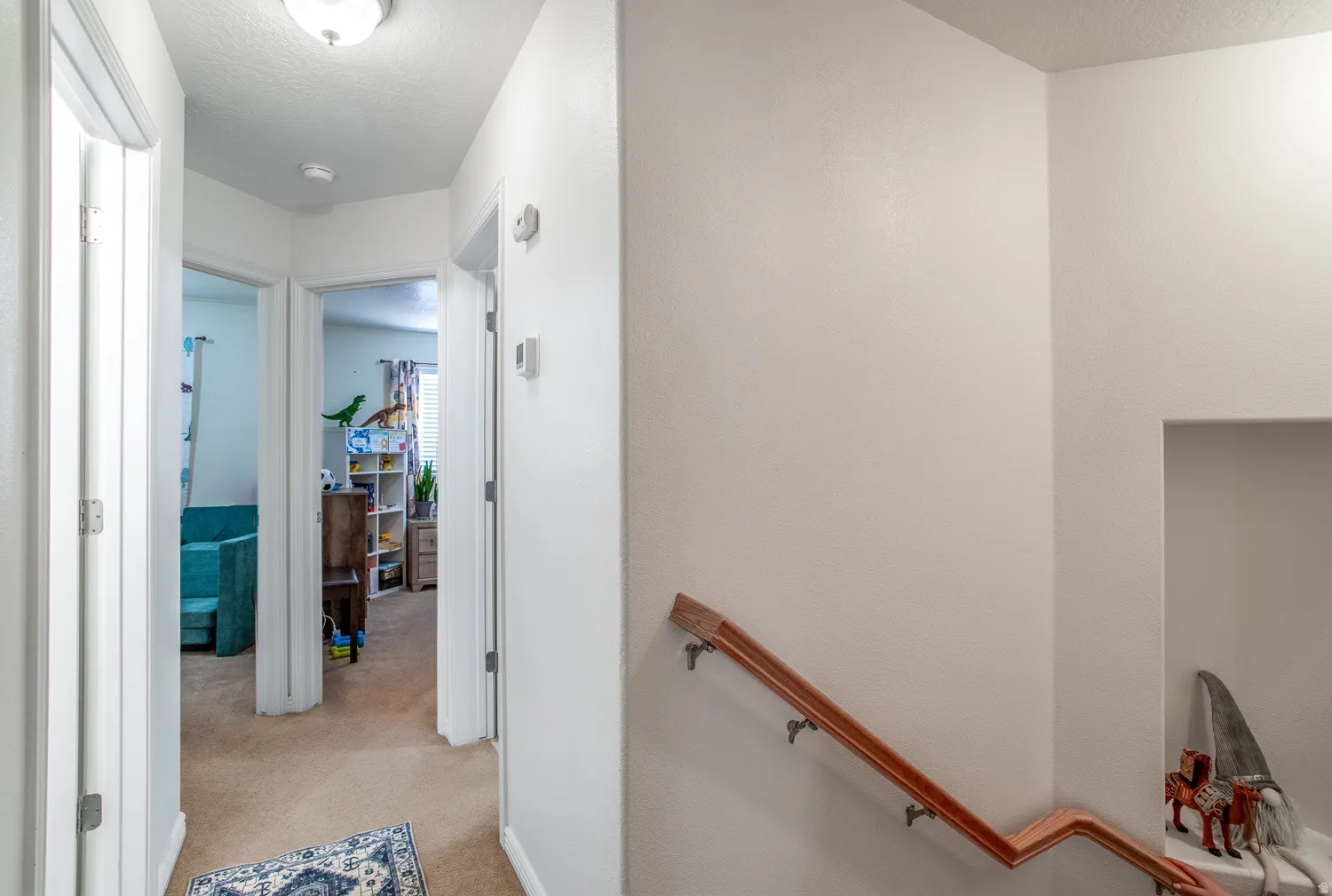 Hallway featuring neutral-toned carpet flooring and white walls