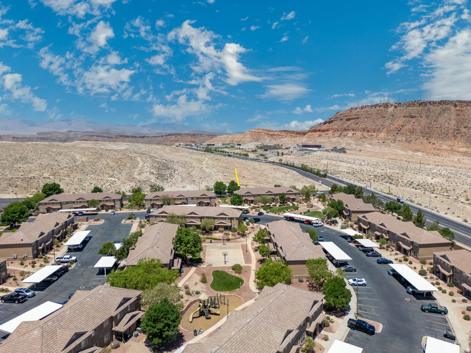 Aerial view of a residential complex featuring multiple buildings with tile roofs and stucco exteriors