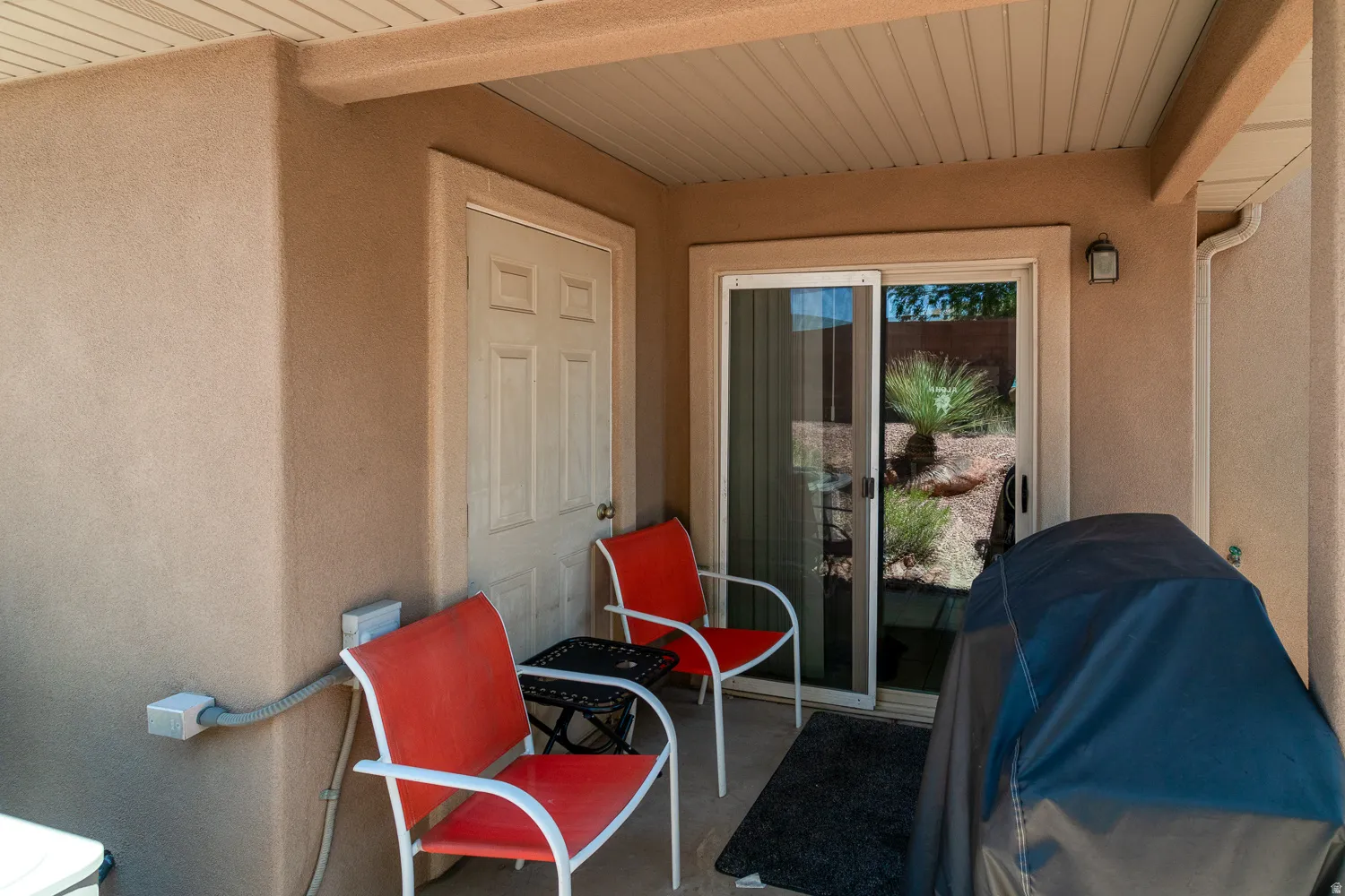 Covered patio with stucco walls and a paneled ceiling