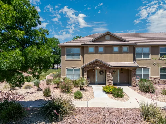 Stucco exterior featuring a tiled roof and stone-clad entryways