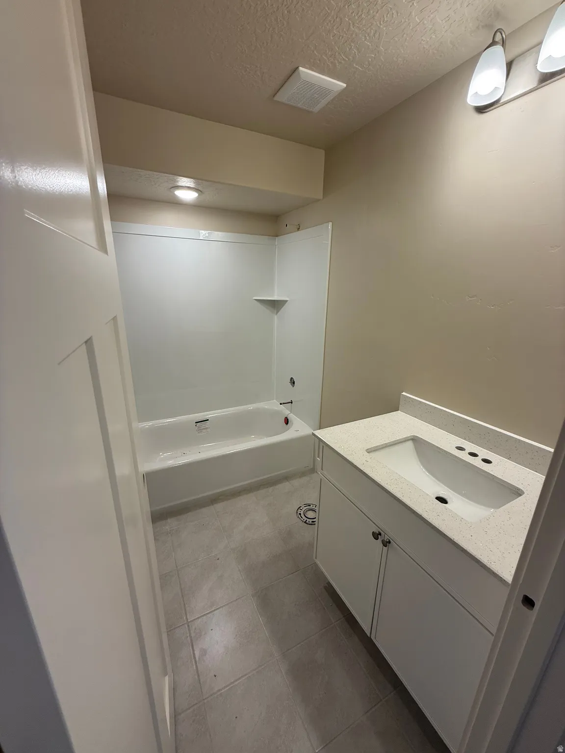 Contemporary bathroom featuring a white vanity with an integrated sink and light-colored countertop