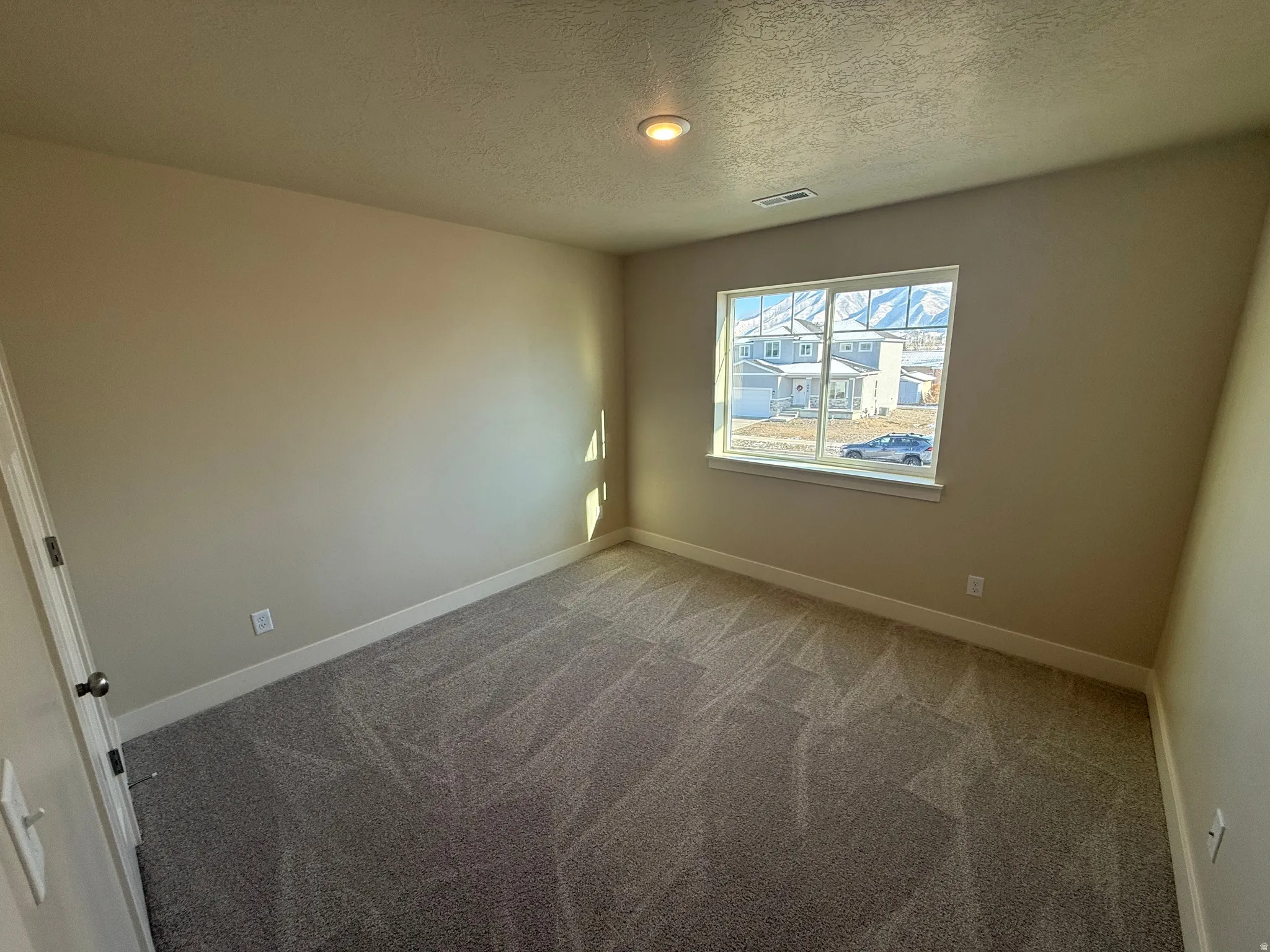 Interior room featuring neutral wall paint, patterned carpeting, and white trim
