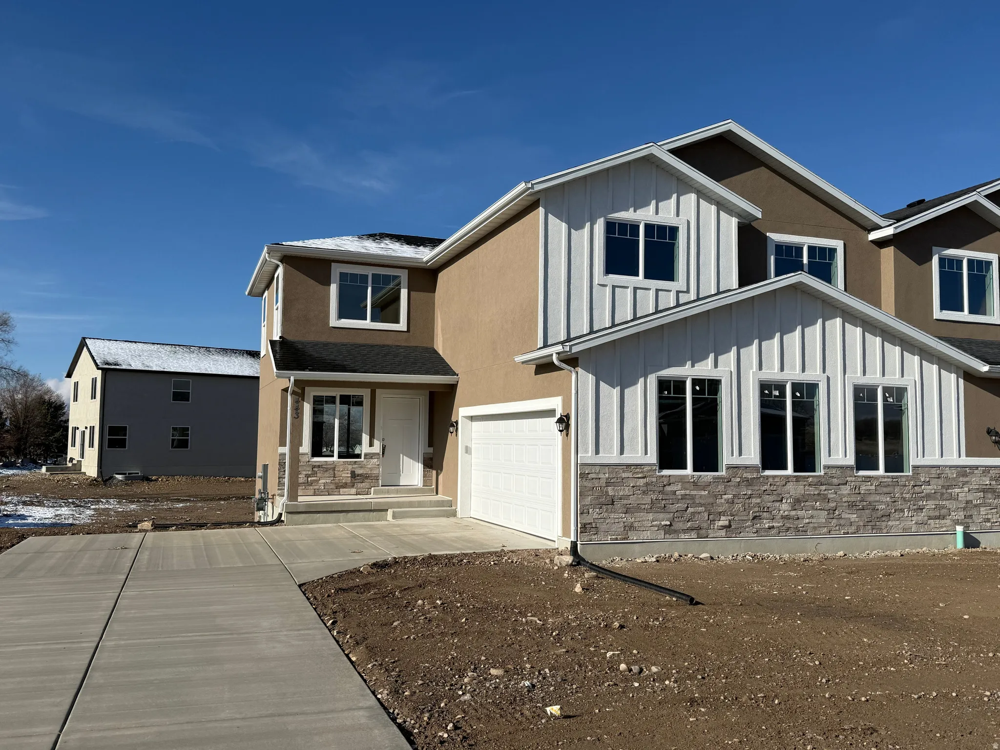 Contemporary facade featuring stucco and vertical white siding accents
