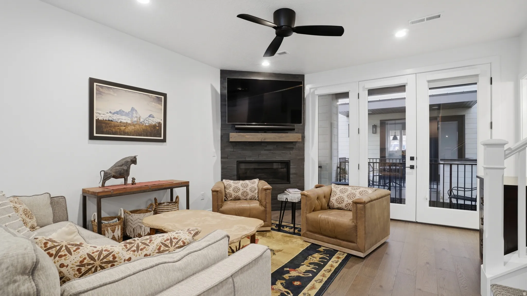 Living area featuring wood-finish flooring, a contemporary ceiling fan, and recessed lighting